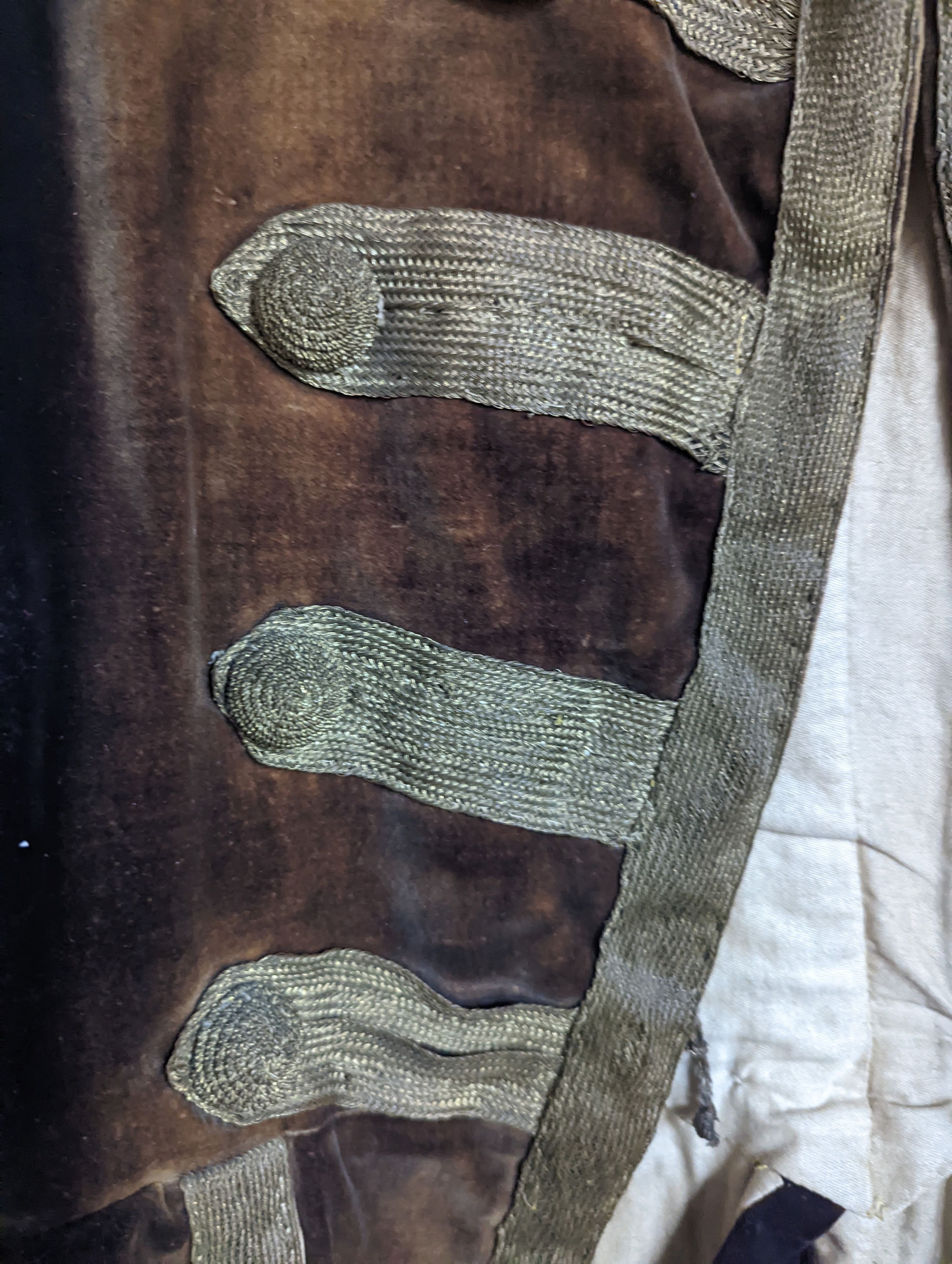 A Georgian gents cream damask waistcoat, a similar waistcoat with beading applied later and a velvet and gold braided tailcoat